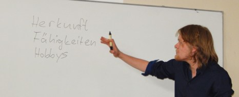 Rafael Rickfelder bewegt sich Richtung Tafel. Dort hebt er einen Stift auf und bearbeitet langsam eine Liste der verschiedenen menschlichen Qualitäten, die zur Beurteilung durch andere beitragen. Foto: Allison Meakem
