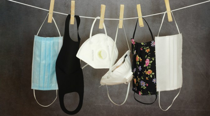 Verschiedene Maskentypen hängen auf einer Wäscheleine