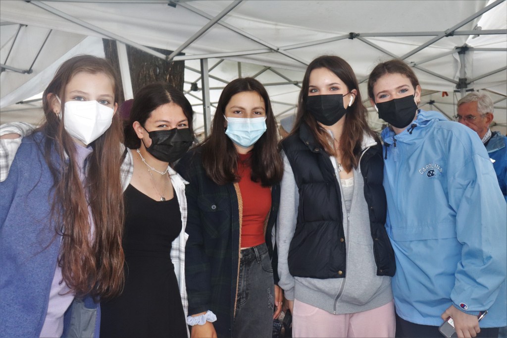 Fünf weibliche Teenager unter einem Marktzelt.