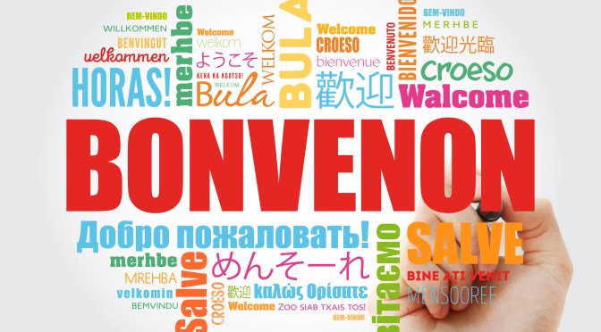 Bonvenon (Willkommen in Esperanto) in roter Schrift mit Übersetzungen in andere Sprachen in bunter Schrift